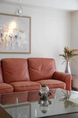 a living room with a leather couch and a glass table at Bursa Park Apart Hotel in Bursa