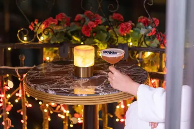 a person holding a wine glass on a table with a candle at Hotel De Reve Galata-Special Class in Istanbul