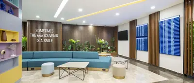a living room with a blue couch and a table at Hampton By Hilton Istanbul Airport, Arnavutkoy in Istanbul