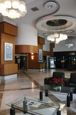 a lobby with chairs and a table and chandeliers at Byotell Istanbul in Istanbul