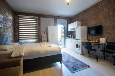 a bedroom with a large bed and a brick wall at Zelya Istanbul Flats in Istanbul