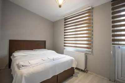 a bedroom with a bed with white sheets and a window at Zelya Istanbul Flats in Istanbul