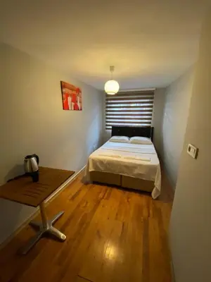 a small bedroom with a bed and a table at Zelya Istanbul Flats in Istanbul