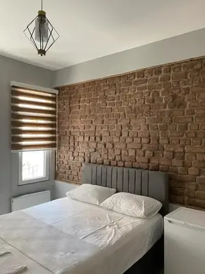 a bed in a bedroom with a brick wall at Zelya Istanbul Flats in Istanbul
