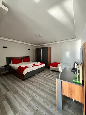 a bedroom with two beds and a desk in it at Deniz Hotel Kumburgaz in Buyukcekmece