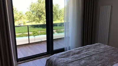 a bedroom with a large glass door looking out at a balcony at ANTİGONİA BUTİK OTEL in İznik