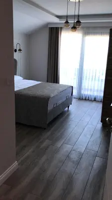 a bedroom with a bed and a wooden floor at ANTİGONİA BUTİK OTEL in İznik