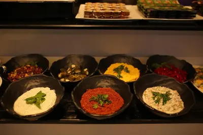 a bunch of different types of food in black bowls at HaciBayramHotel in Istanbul