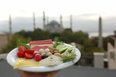 a plate of food with cheese and vegetables on it at HaciBayramHotel in Istanbul