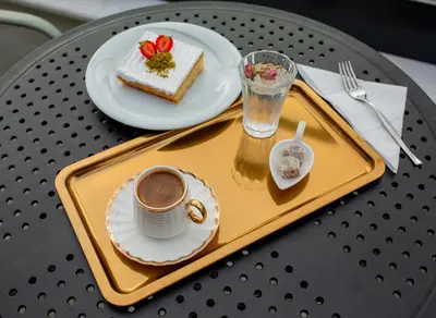 a tray with a cup of coffee and a piece of cake at HaciBayramHotel in Istanbul