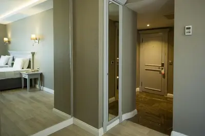 a room with a bed and a door with a mirror at Semsan Hotel in Istanbul