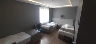 a small room with two beds and a window at Semsan Hotel in Istanbul