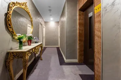 a hallway with a gold console and a mirror at Valide Hotel in Istanbul