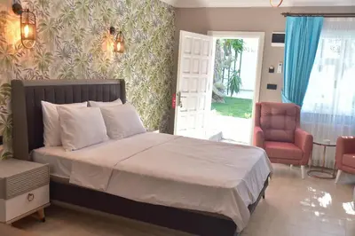 a bedroom with a bed and a chair and a window at Noya Köşk Otel in Adalar