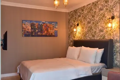 a hotel room with two beds and a painting on the wall at Noya Köşk Otel in Adalar