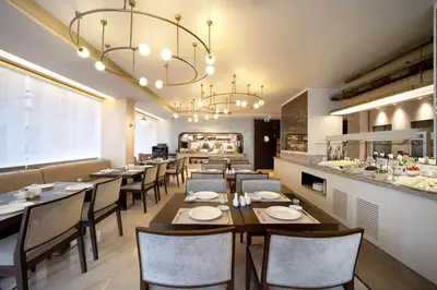a restaurant with tables and chairs and a chandelier at Bentley Hotel Bosphorus - Special Class in Istanbul