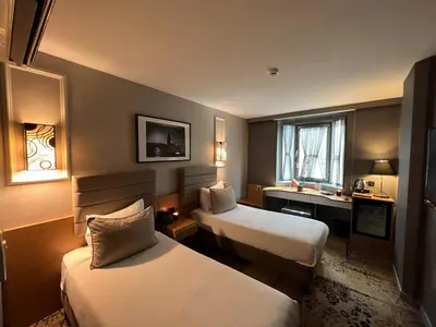 a hotel room with two beds and a desk at All Seasons Hotel in Istanbul