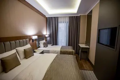 a hotel room with two beds and a flat screen tv at Hamitbey Hotel Yenikapı in Istanbul