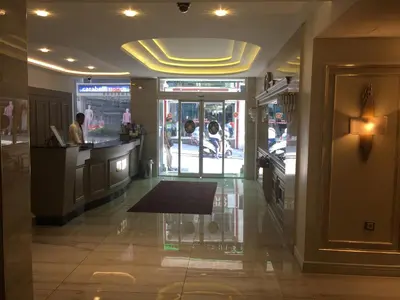 a lobby of a restaurant with a man at a counter at Laleli Gonen Hotel in Istanbul