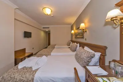 a hotel room with two beds and a desk at Laleli Gonen Hotel in Istanbul