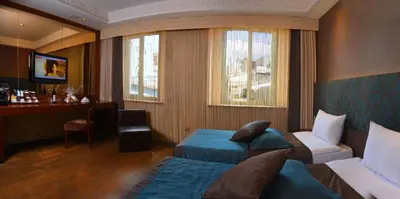 a hotel room with two beds and a desk at Pera Tulip Hotel & Spa in Istanbul