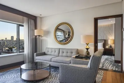 a living room with a couch and a table and a mirror at Conrad Istanbul Bosphorus in Istanbul