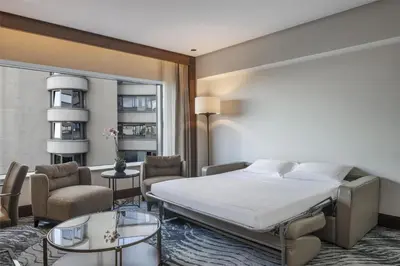 a bedroom with a bed and a living room at Conrad Istanbul Bosphorus in Istanbul