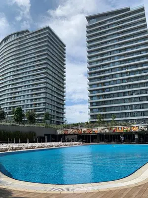 a large swimming pool in front of two tall buildings at The Superior Living Batışehir in Istanbul