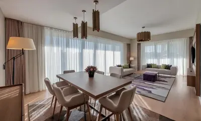 a living room with a dining room table and chairs at The Superior Living Batışehir in Istanbul