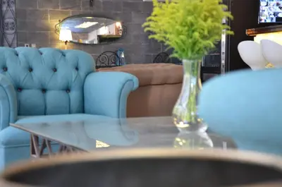 a vase of flowers on a glass table with a couch at Grand Park Hotel Corlu City Center Bed and Breakfast in Corlu