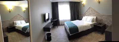 a hotel room with two beds and a mirror at Grand Park Hotel Corlu City Center Bed and Breakfast in Corlu