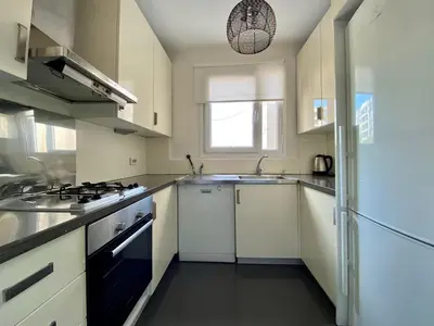 a kitchen with white cabinets and a sink and a refrigerator at A Million Dollar View In the Heart of the City in Istanbul