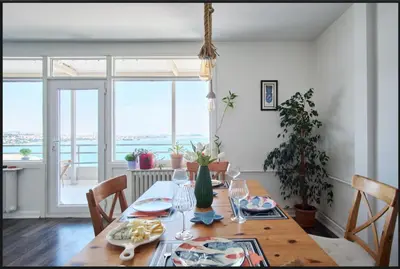 a dining room with a wooden table and a large window at A Million Dollar View In the Heart of the City in Istanbul