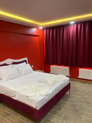 a bedroom with a large bed with red walls at CEMRE SUIT in Istanbul