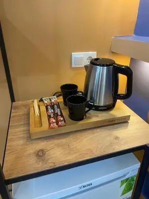 a tea kettle and two cups on a wooden cutting board at CEMRE SUIT in Istanbul