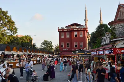 a crowd of people walking around an open air market at Çırağan's Omnia Hotel in Istanbul
