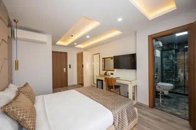 a bedroom with a bed and a desk and a sink at Luxury Airport Hotel By Zazzoni-İstanbul Airport in Arnavutköy