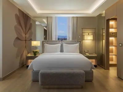 a bedroom with a white bed and a large window at Mövenpick Hotel Istanbul Bosphorus in Istanbul