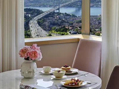 a table with plates of food and a vase with flowers at Mövenpick Hotel Istanbul Bosphorus in Istanbul