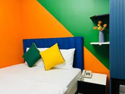a bed with two pillows and a colorful wall at Apex Hotel in Istanbul