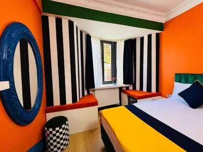 a bedroom with a bed and an orange wall at Apex Hotel in Istanbul