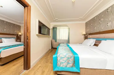 a hotel room with two beds and a mirror at Grand Yavuz Hotel Sultanahmet in Istanbul
