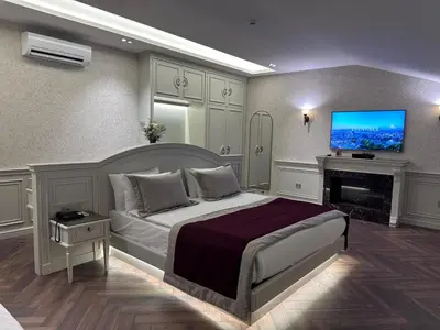 a bedroom with a bed and a tv on the wall at Grand Yavuz Hotel Sultanahmet in Istanbul