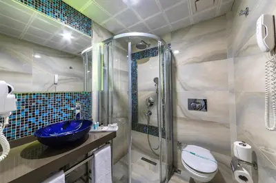a bathroom with a blue sink and a shower at Grand Yavuz Hotel Sultanahmet in Istanbul