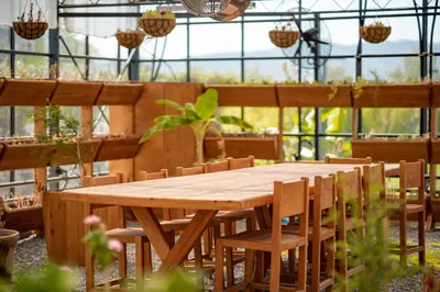 a wooden table and chairs in a greenhouse at Pınar Otel in Erdek