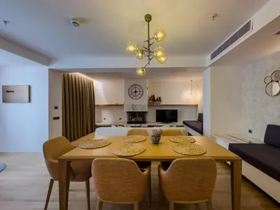a dining room and living room with a table and chairs at Pınar Otel in Erdek