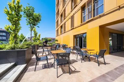 a patio with tables and chairs next to a building at Cebeci Residence Pendik in Istanbul