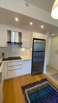 a kitchen with white cabinets and a stainless steel refrigerator at Cebeci Residence Pendik in Istanbul
