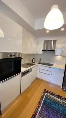 a kitchen with white cabinets and a rug on the floor at Cebeci Residence Pendik in Istanbul