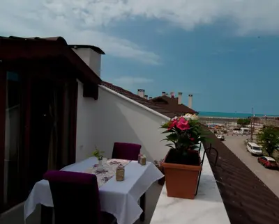 a table on a balcony with a view of a city at DEFNE OTEL in Sile